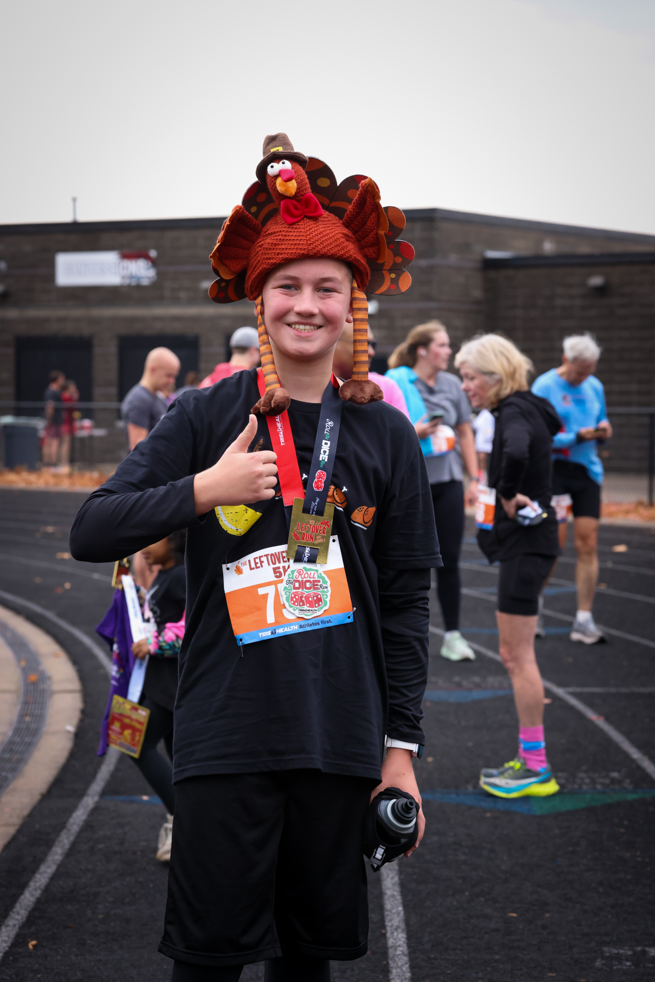 A young 5K participant wearing a turkey hat and finish medal